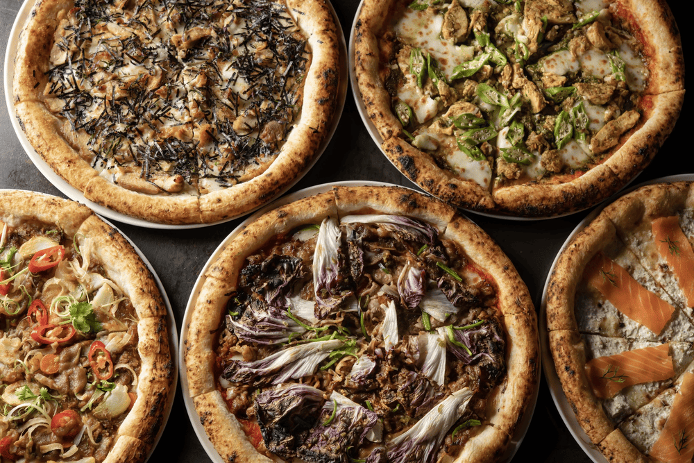 The pizzas here are baked in a wood-fired oven, preserving their signature artisanal flavor (Source: Pizza 4P’s)